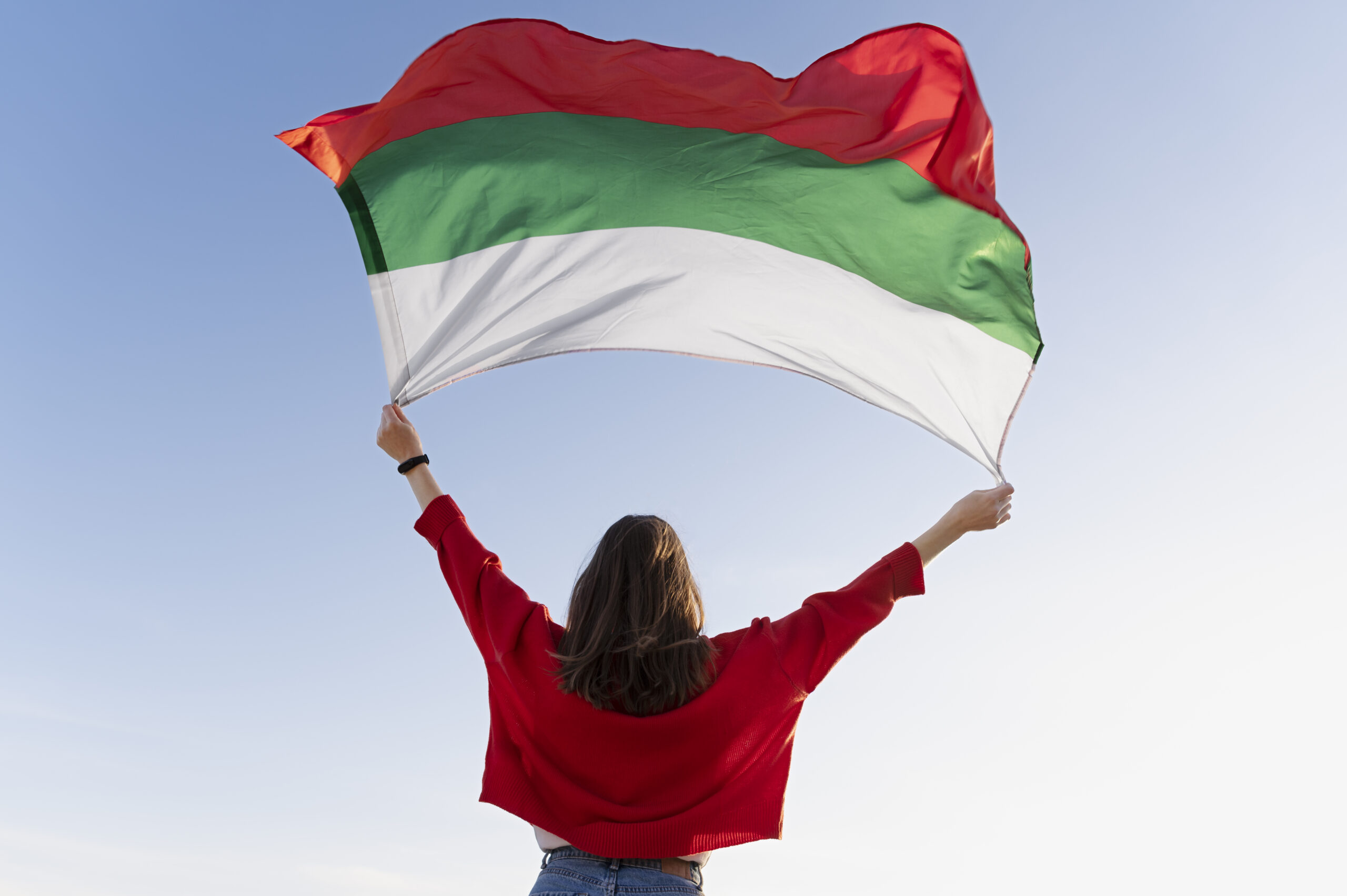 woman-holding-bulgarian-flag-against-blue-flag